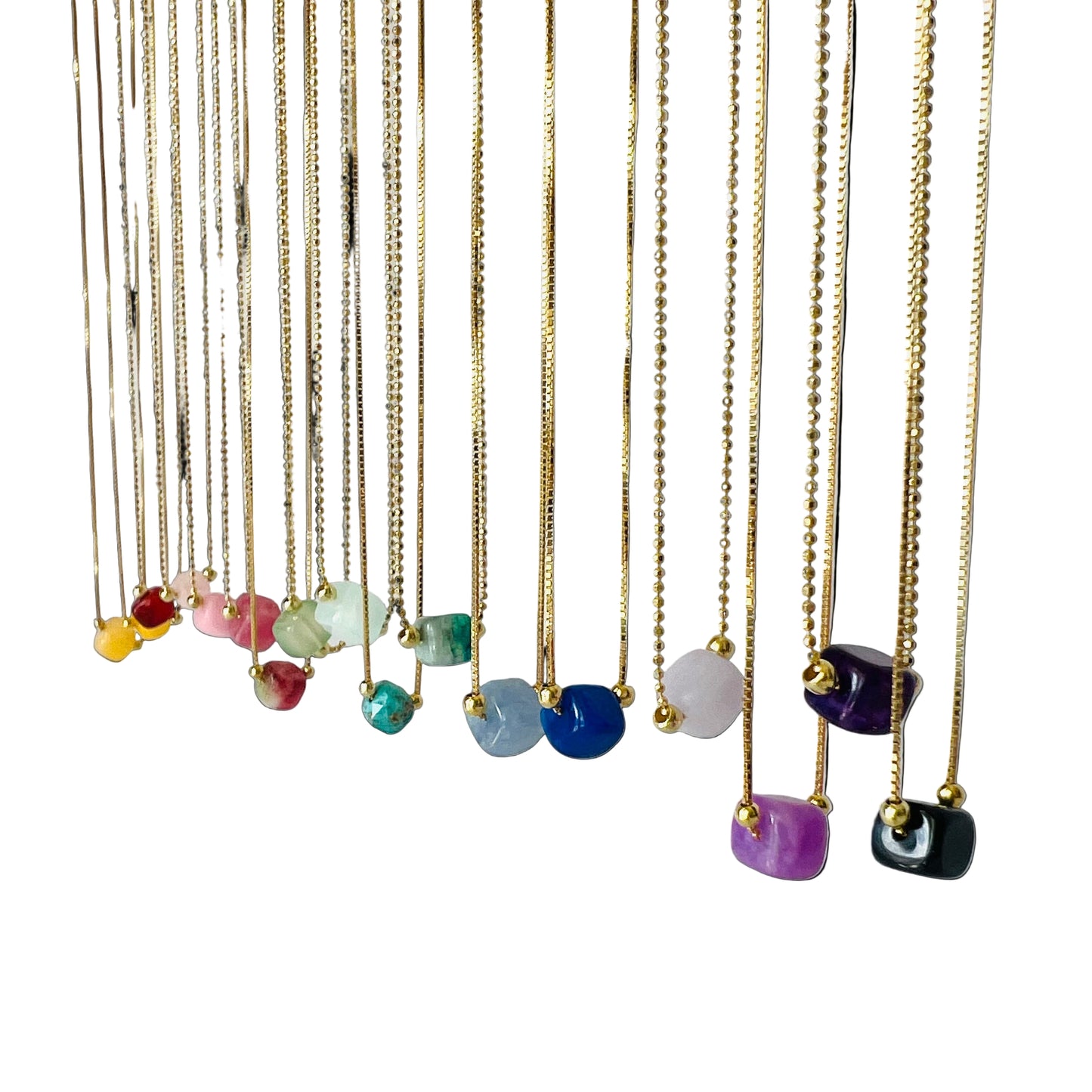 Necklaces with colorful gemstones hanging against a white background