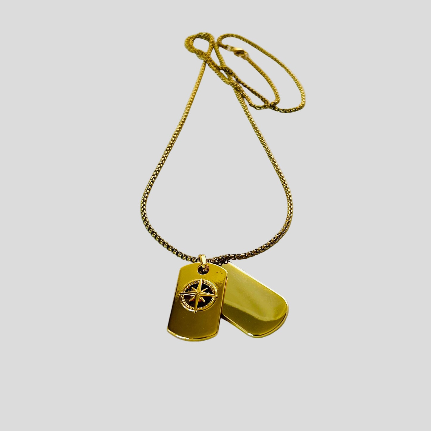 Gold necklace with two dog tags on a white background