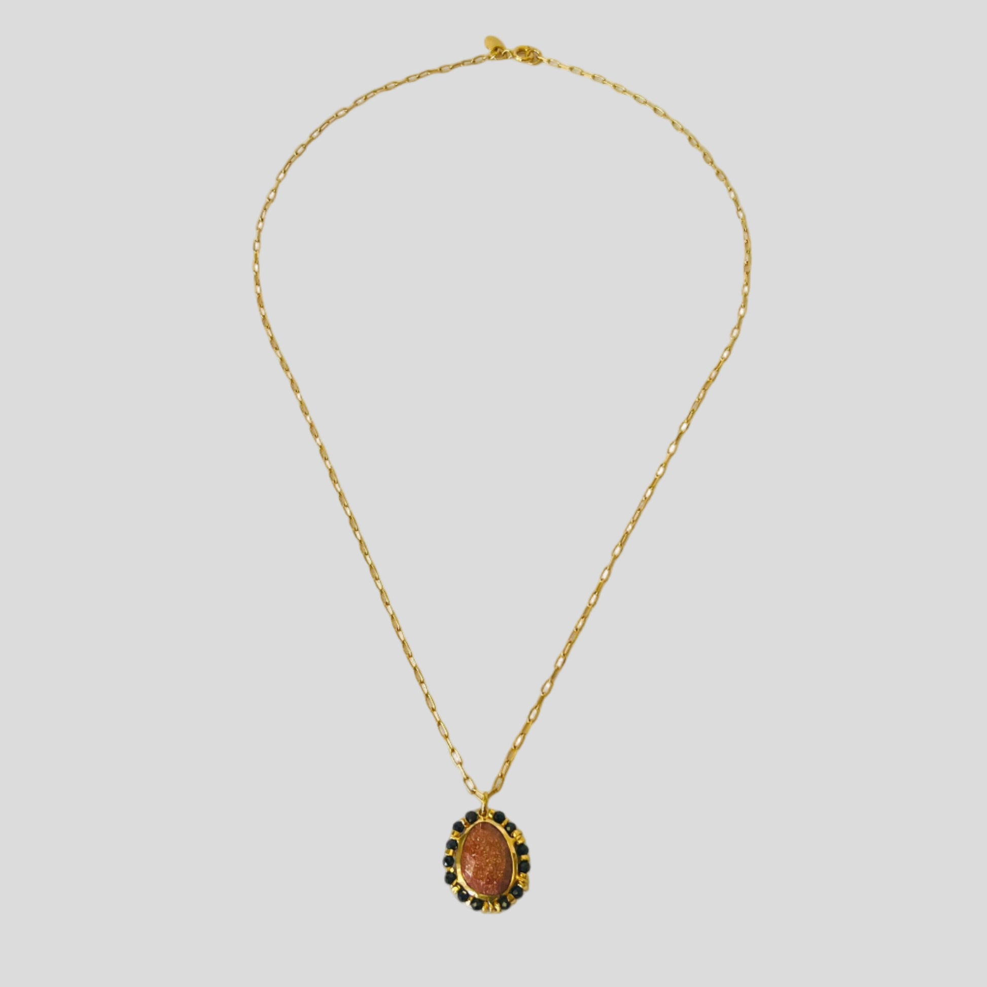 Gold necklace with a pendant on a white background