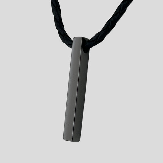 Black rectangular pendant on a black cord against a light gray background