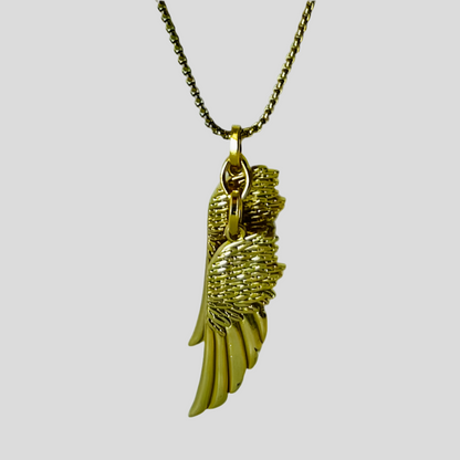 Gold angel wing necklace on a light gray background
