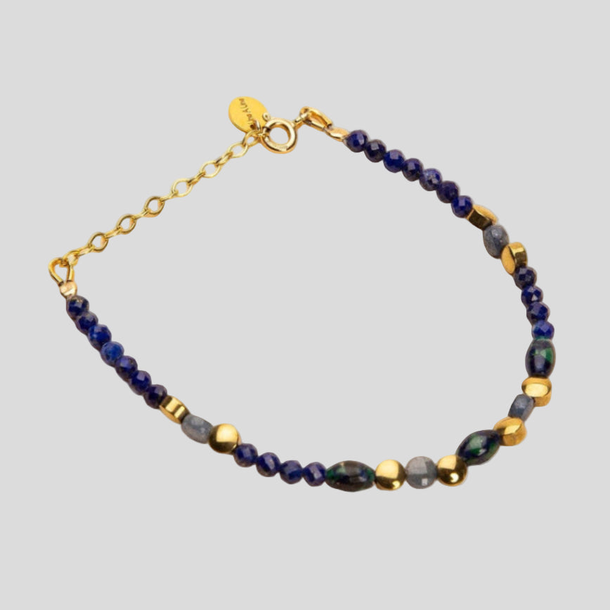 Bracelet with blue and gold beads on a beige background