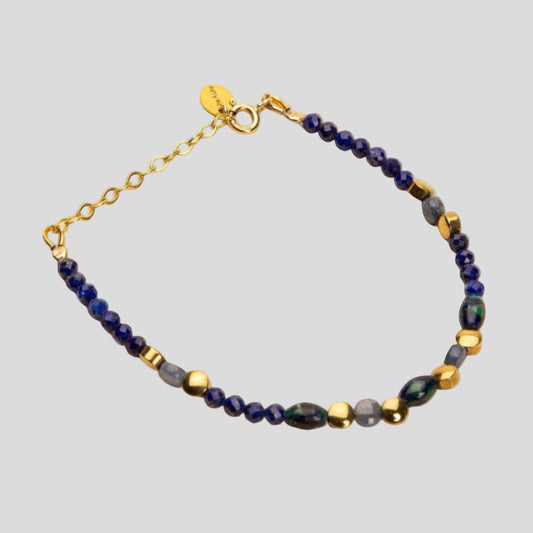 Bracelet with blue and gold beads on a beige background